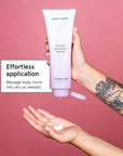 A hand squeezing Grace & Stella's lavender body lotion (473ml) free gift from a tube onto another hand against a pink background, with text highlighting "effortless application.